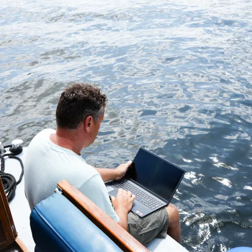 arbeiten am Laptop auf dem Boot 